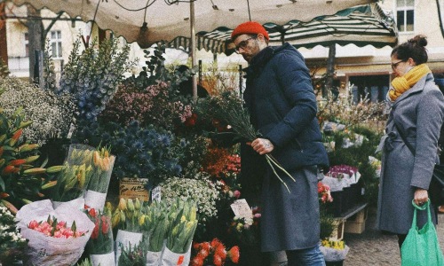 a person standing next to a flower stand