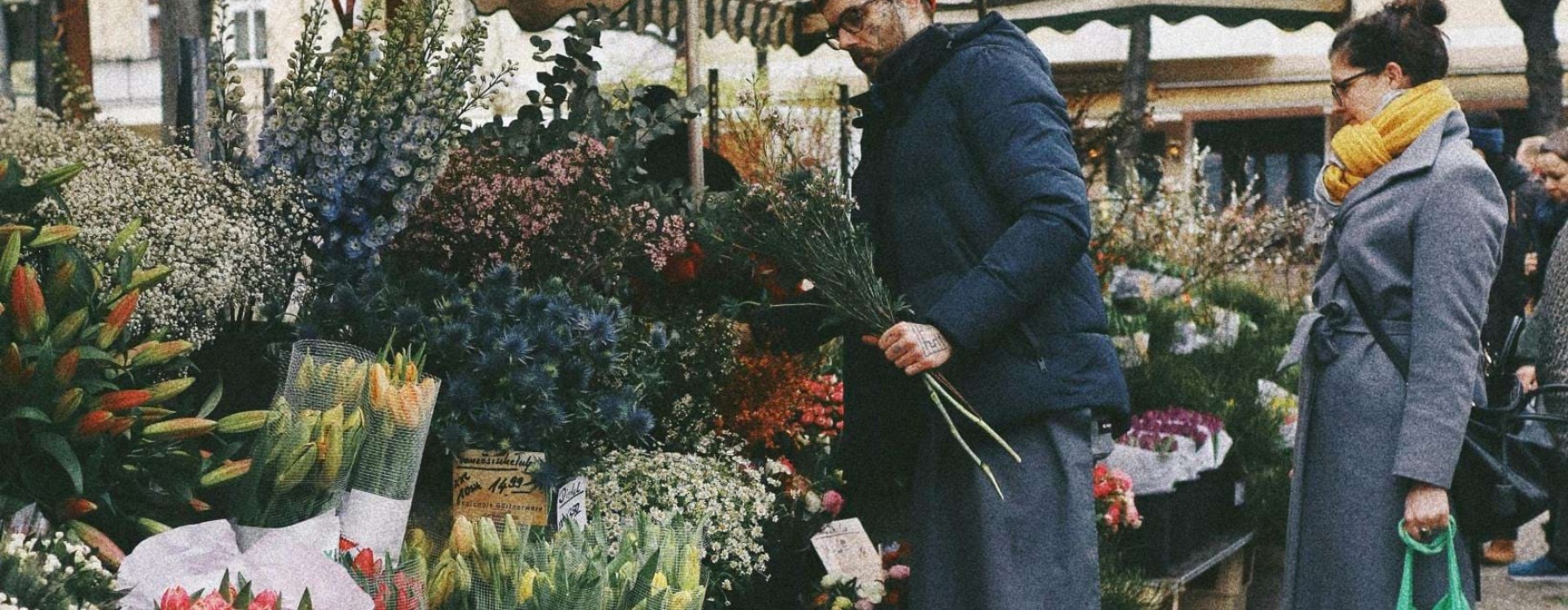 a person standing next to a flower stand